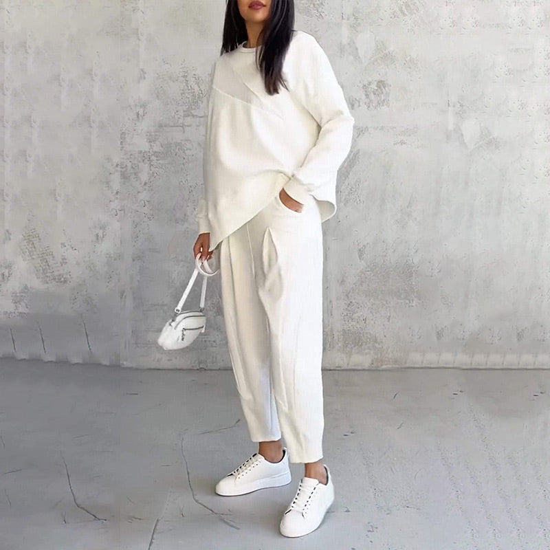 Női szett, amely egy hosszú ujjú blúzból és egy szabálytalan szegélyű nadrágból áll.