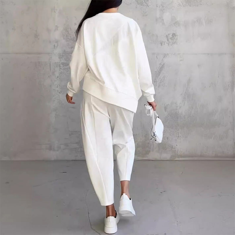 Női szett, amely egy hosszú ujjú blúzból és egy szabálytalan szegélyű nadrágból áll.